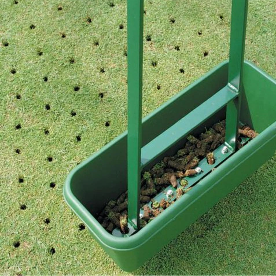 Aeration corer collector box full of soil cores on a freshly aerated golf green