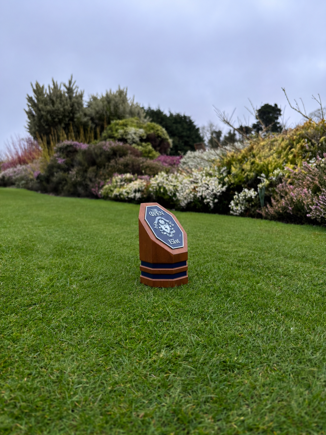 Custom golf tee marker with a club crest on a golf course tee