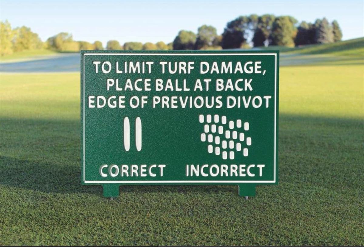 Green divot instructional golf course sign reading To limit turf damage, place ball at back edge of previous divot, with correct and incorrect divot diagrams