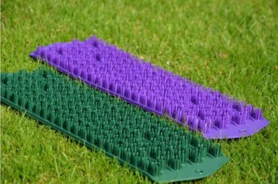 Green and purple golf fairway mats laid on grass